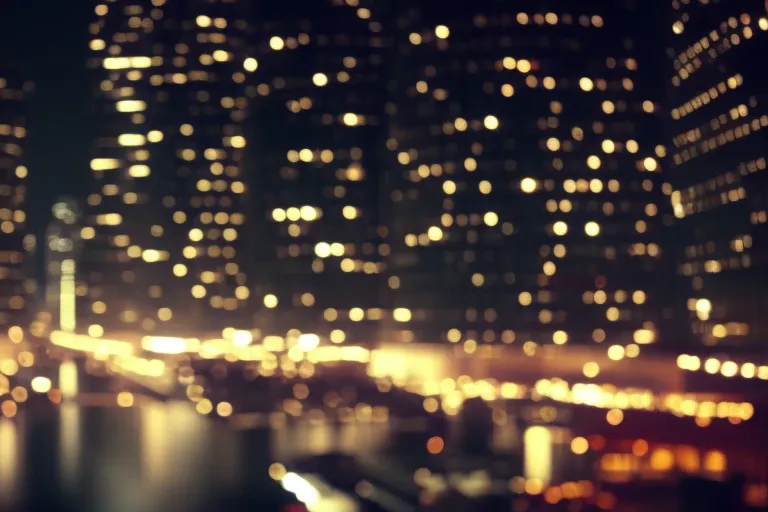 A vibrant and bustling cityscape at night, with towering buildings and bright lights reflecting off the streets below.