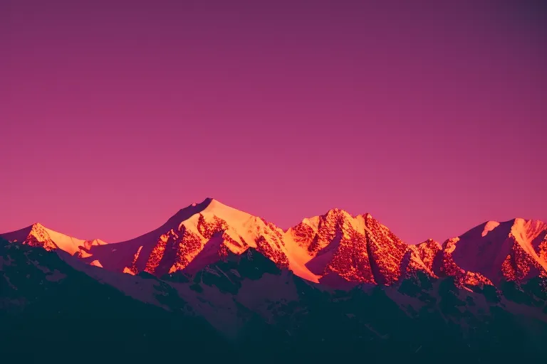 A snow-covered mountain range at dawn, with the first light just peeking over the horizon, casting a pink and orange glow on the peaks.